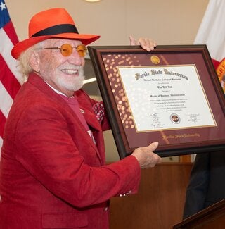 Dr. Herbert Wertheim and his replica diploma from FSU's Wertheim College