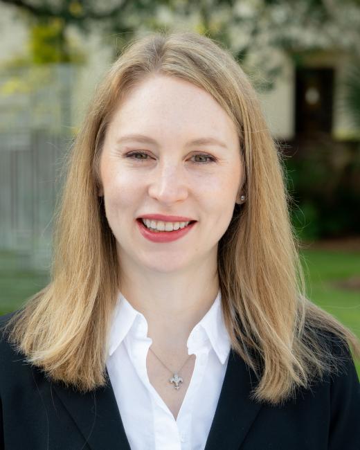 Cammy Crolic wearing a white dress shirt and a black overcoat